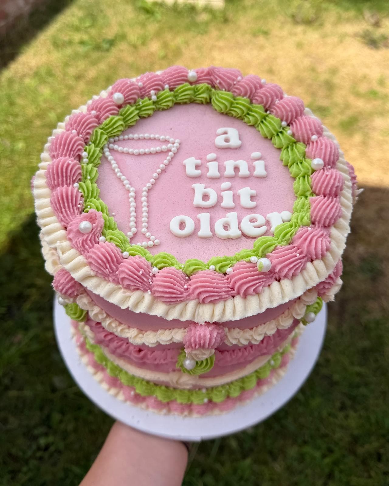 Vintage piped cake reading 'a tini bit older' with a martini glass