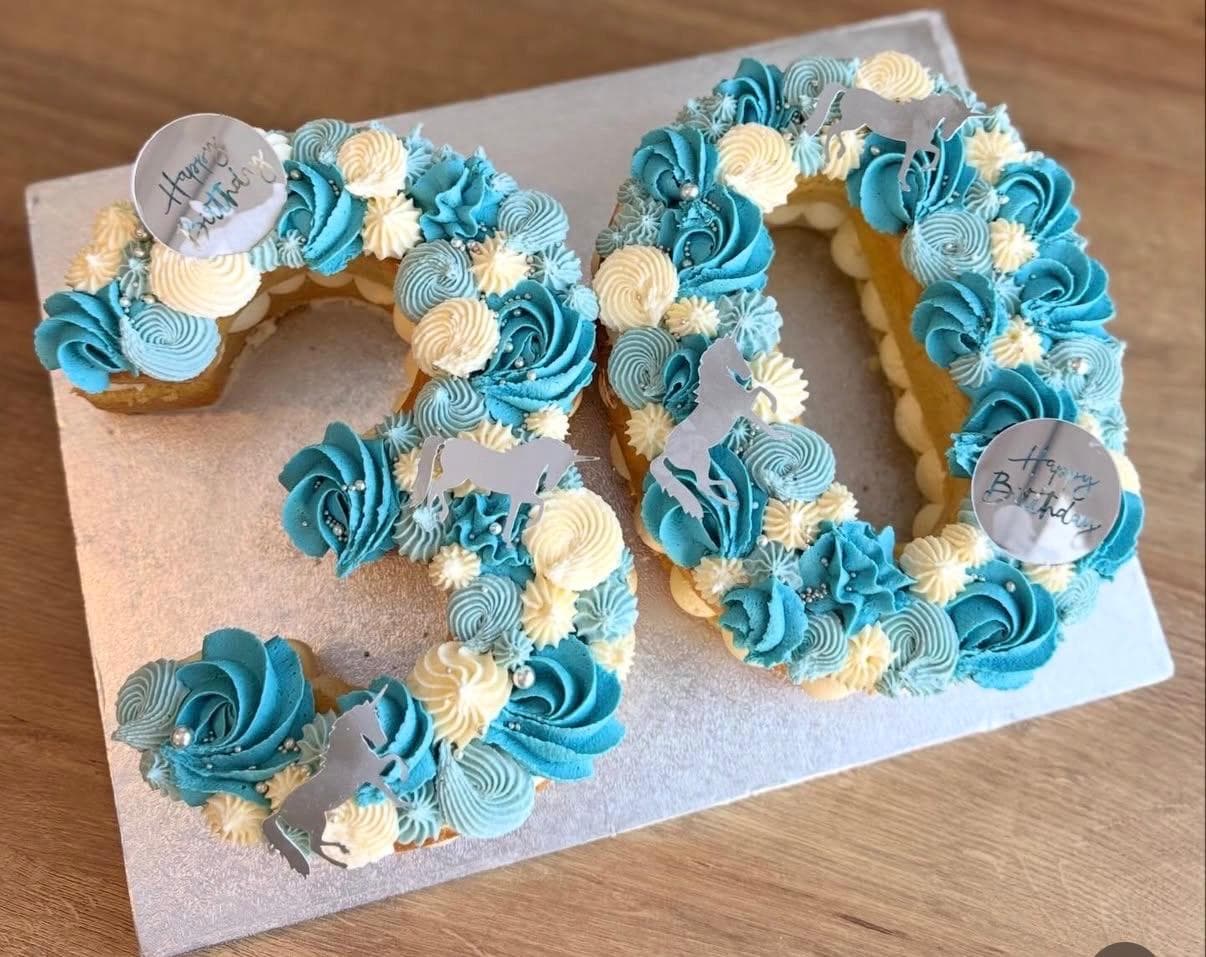 Number 30 cake piped in blue and white buttercream with silver unicorn toppers